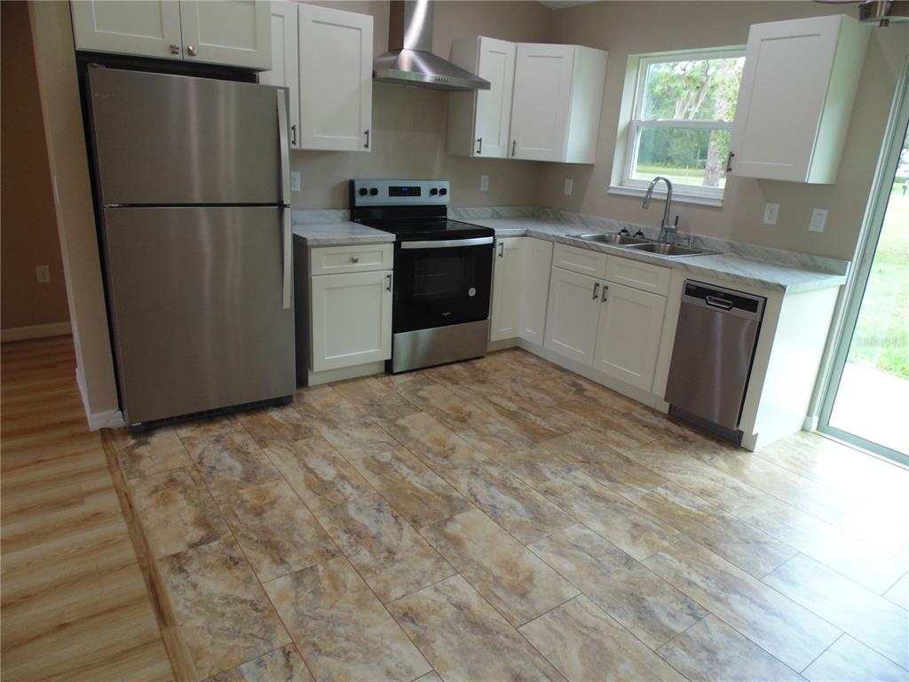 10856 Southwest 79th Avenue Ocala, FL 34476 - Photo 5 of 33 a kitchen with a refrigerator sink and cabinets