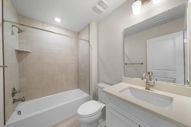 a bathroom with a bathtub shower sink mirror vanity and toilet