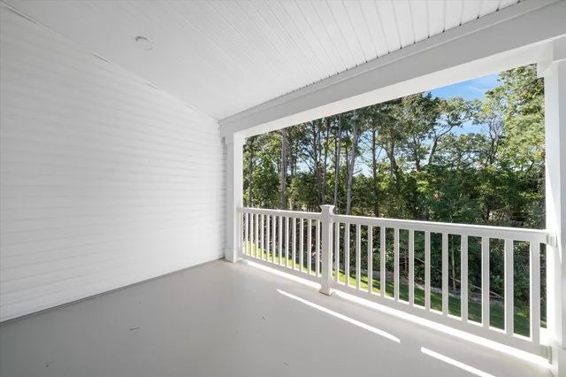 a view of a balcony with floor to ceiling window plants and wooden fence