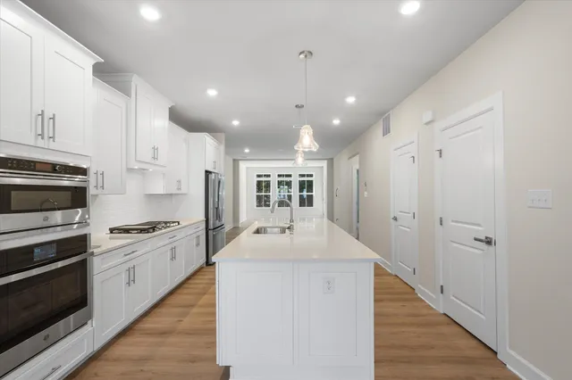 a kitchen with kitchen island a sink stainless steel appliances and cabinets