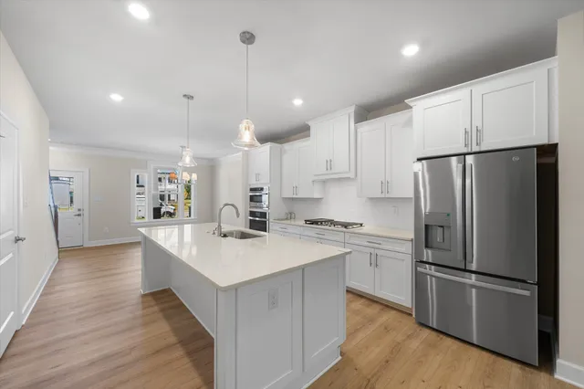 a kitchen with kitchen island white cabinets and stainless steel appliances