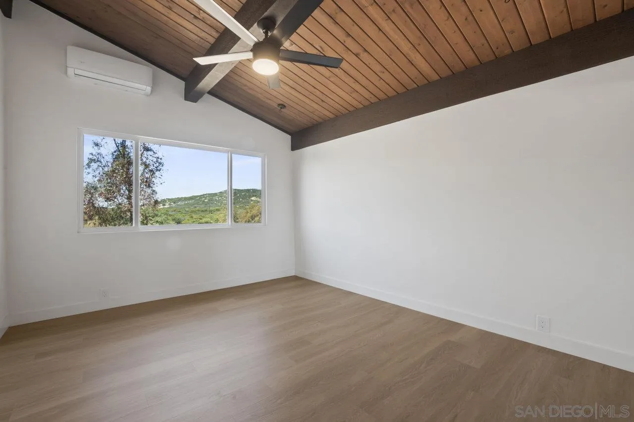 23471 Japatul Valley Road Alpine, CA 91901 - Photo 16 of 57 an empty room with wooden floor and windows