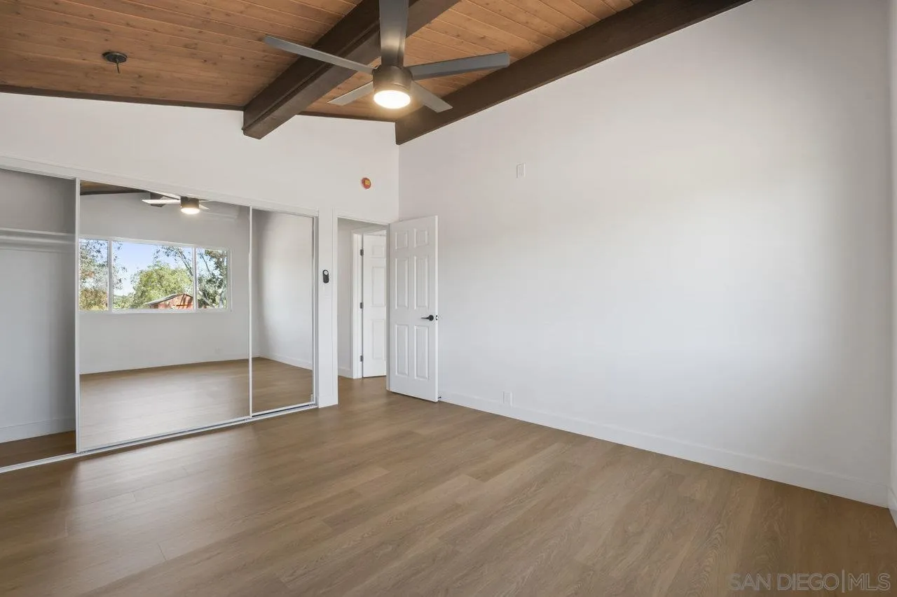 23471 Japatul Valley Road Alpine, CA 91901 - Photo 17 of 57 an empty room with wooden floor and windows