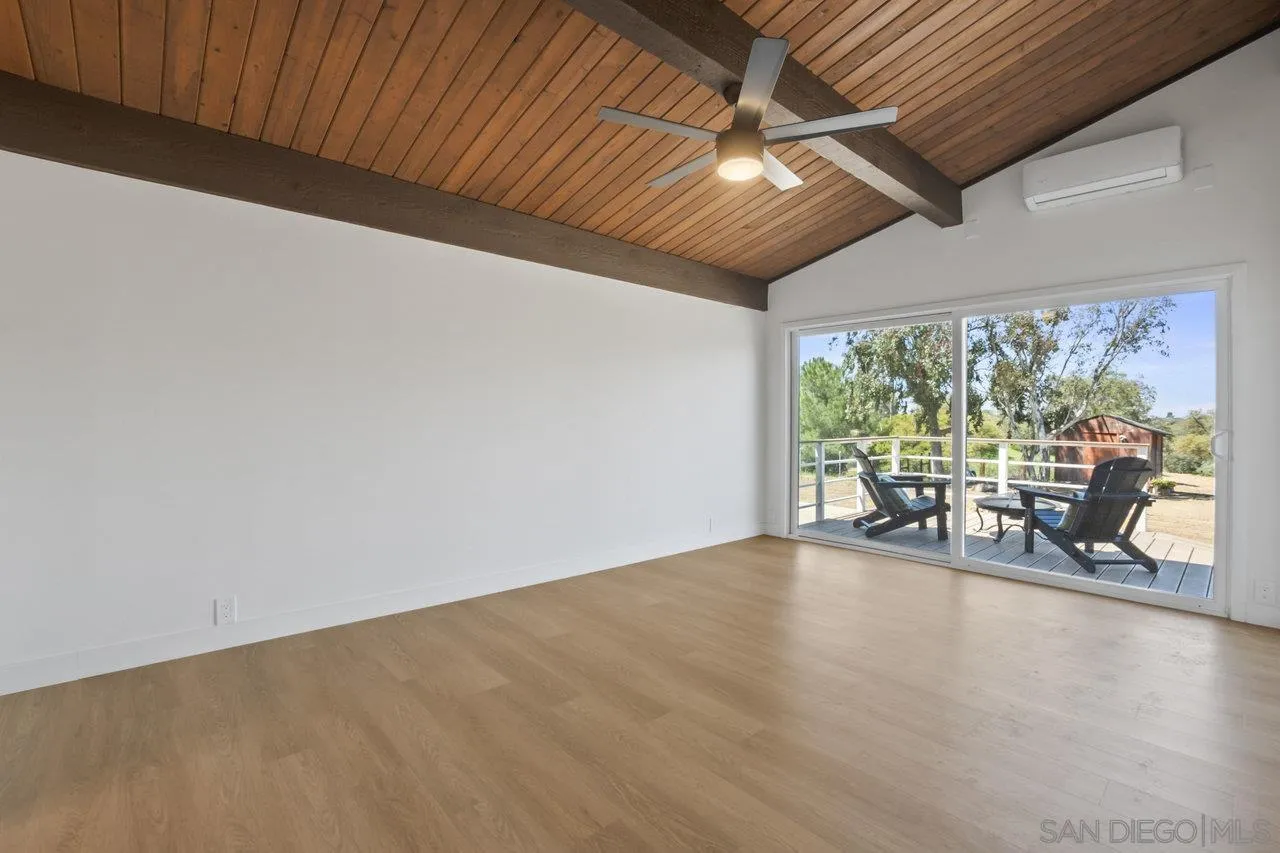 23471 Japatul Valley Road Alpine, CA 91901 - Photo 19 of 57 an empty room with wooden floor and outdoor seating