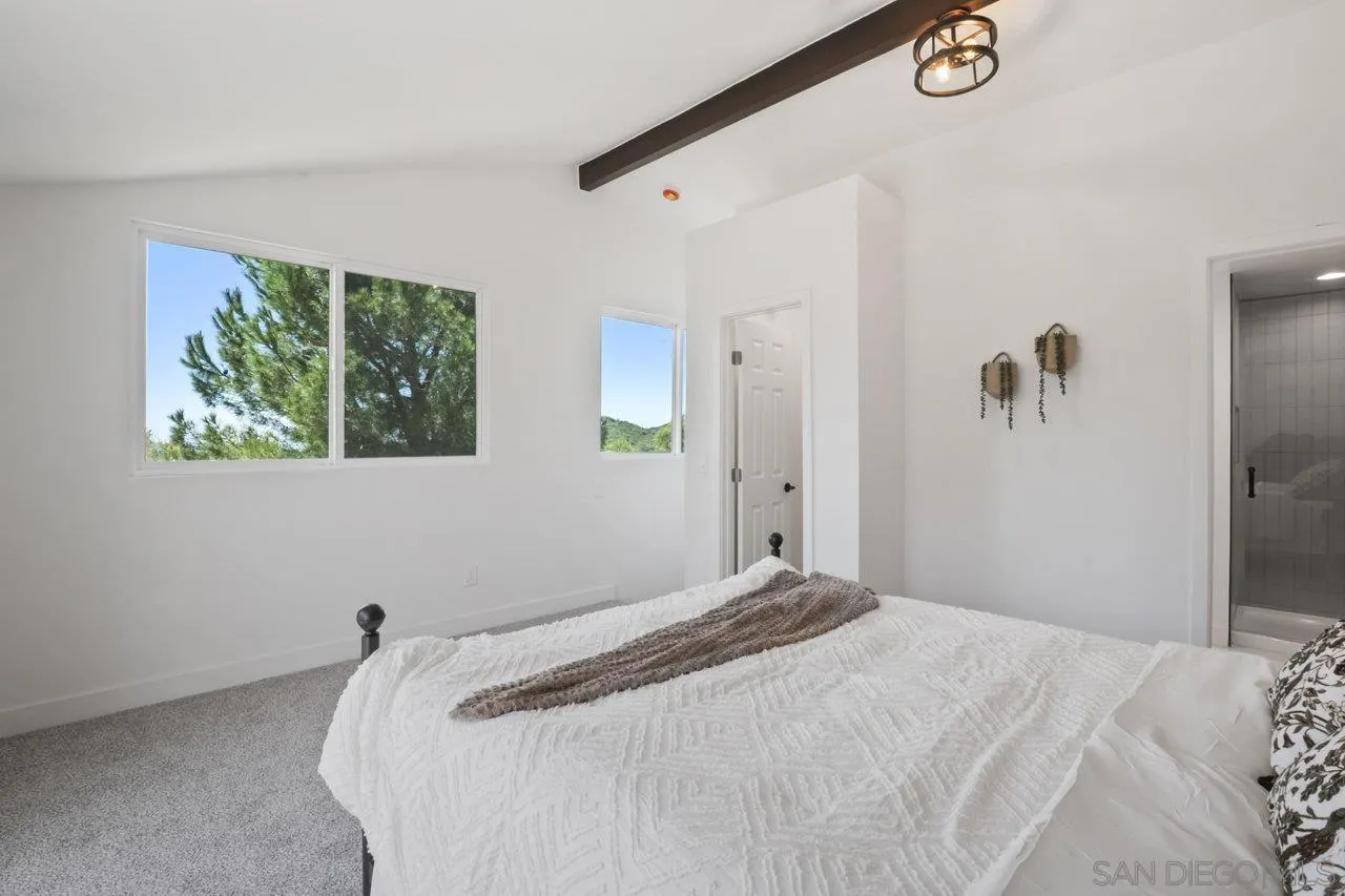 23471 Japatul Valley Road Alpine, CA 91901 - Photo 28 of 57 a bedroom with a bed and a window