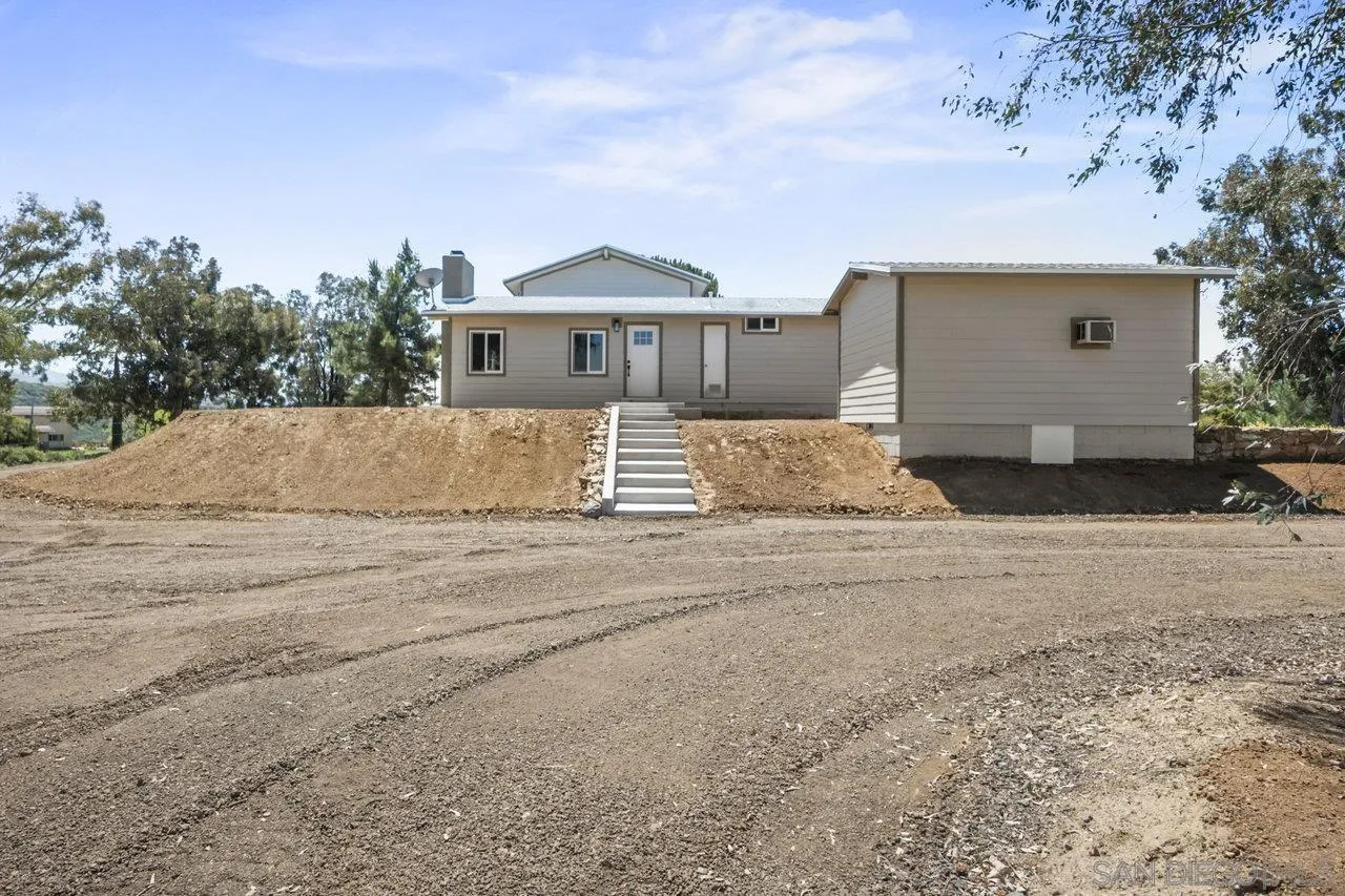 23471 Japatul Valley Road Alpine, CA 91901 - Photo 5 of 57 a front view of a house with a yard and garage