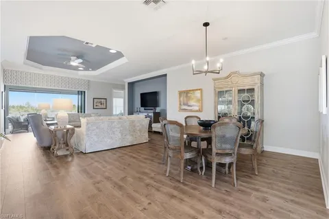 a view of a a dining room with furniture window and wooden floor
