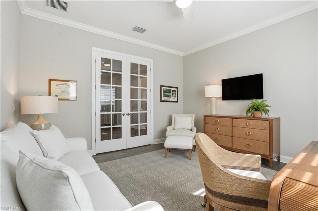 9489 Montelanico Loop Naples, FL 34119 - Photo 17 of 49 Living area featuring french doors, ornamental molding, wood finished floors, and a ceiling fan