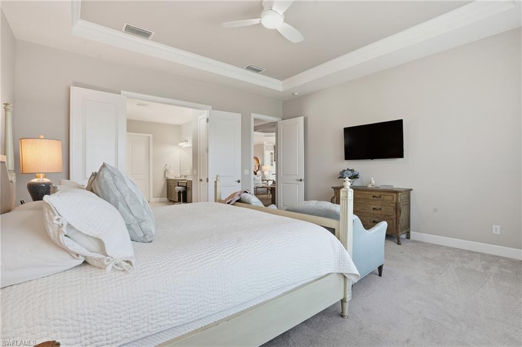 9489 Montelanico Loop Naples, FL 34119 - Photo 20 of 49 Bedroom with carpet floors, ceiling fan, a tray ceiling, and crown molding