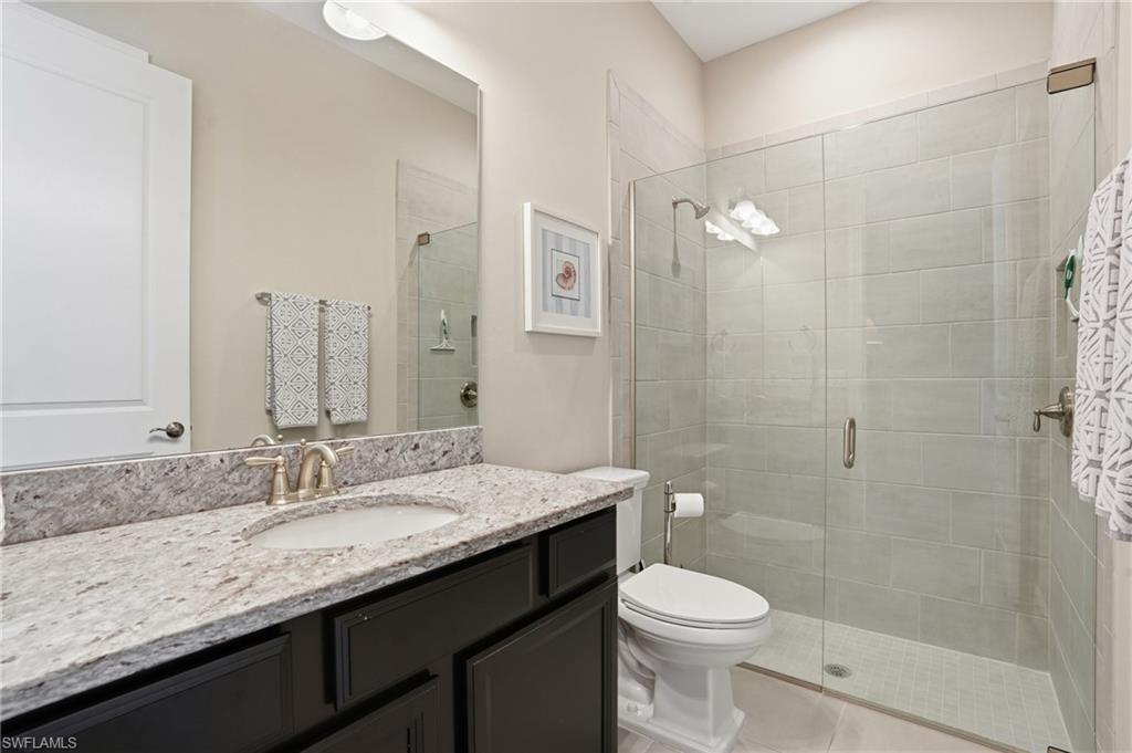 9489 Montelanico Loop Naples, FL 34119 - Photo 27 of 49 Full bathroom featuring vanity and a stall shower