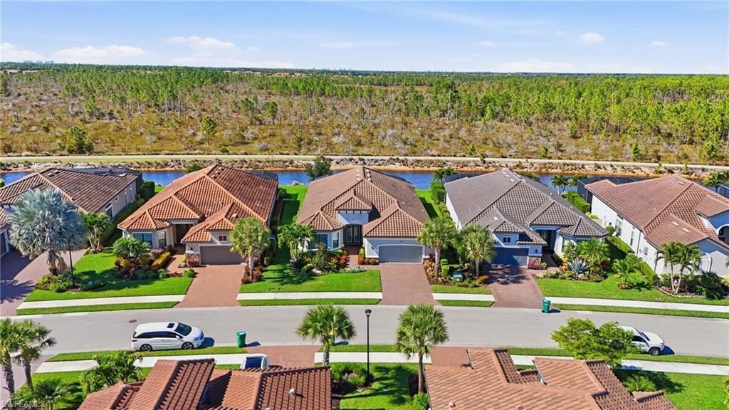 9489 Montelanico Loop Naples, FL 34119 - Photo 3 of 49 Aerial view of residential area with a forest