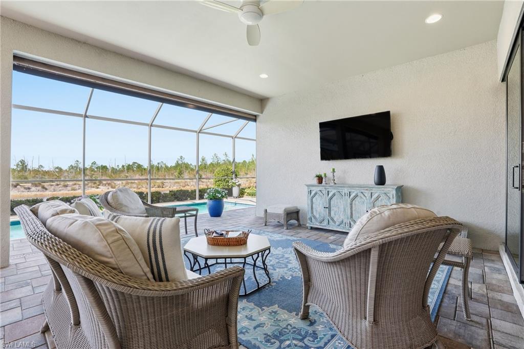 9489 Montelanico Loop Naples, FL 34119 - Photo 32 of 49 View of patio / terrace featuring a sunroom, an outdoor pool, an outdoor living space, and glass enclosure