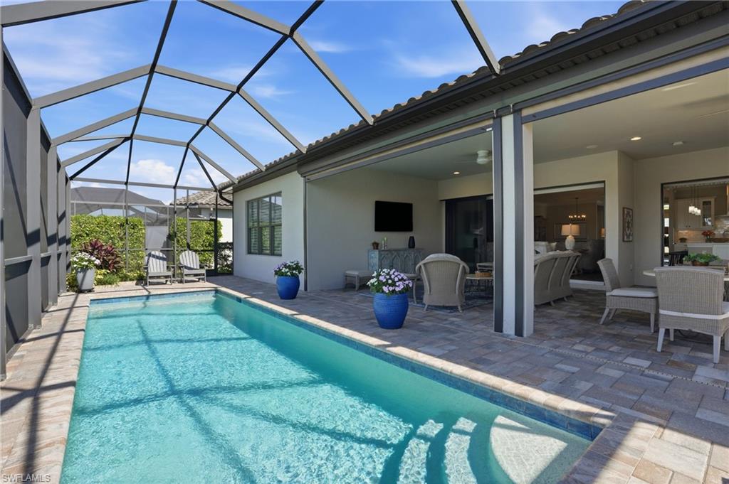 9489 Montelanico Loop Naples, FL 34119 - Photo 36 of 49 Outdoor pool featuring a patio area, glass enclosure, and a sunroom