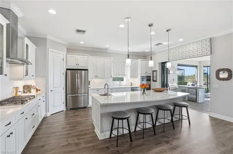 a kitchen with counter top space a sink appliances and wooden floor