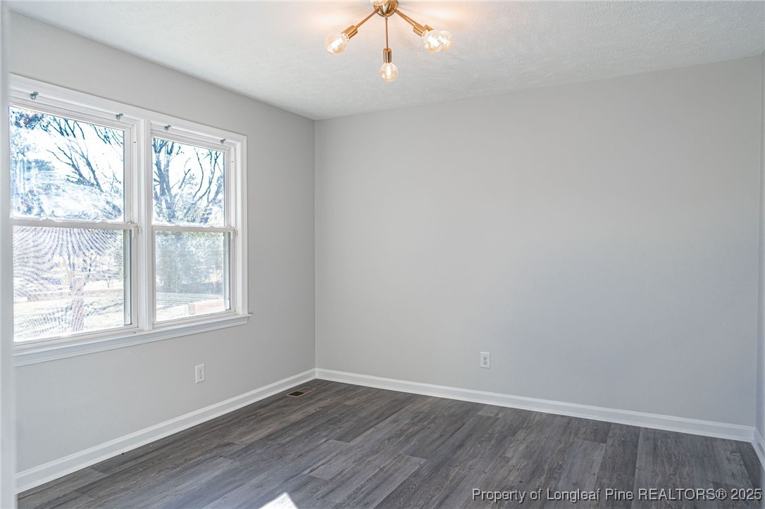 255 Foxcroft Road Whispering Pines, NC 28327 - Photo 12 of 31 an empty room with wooden floor and windows