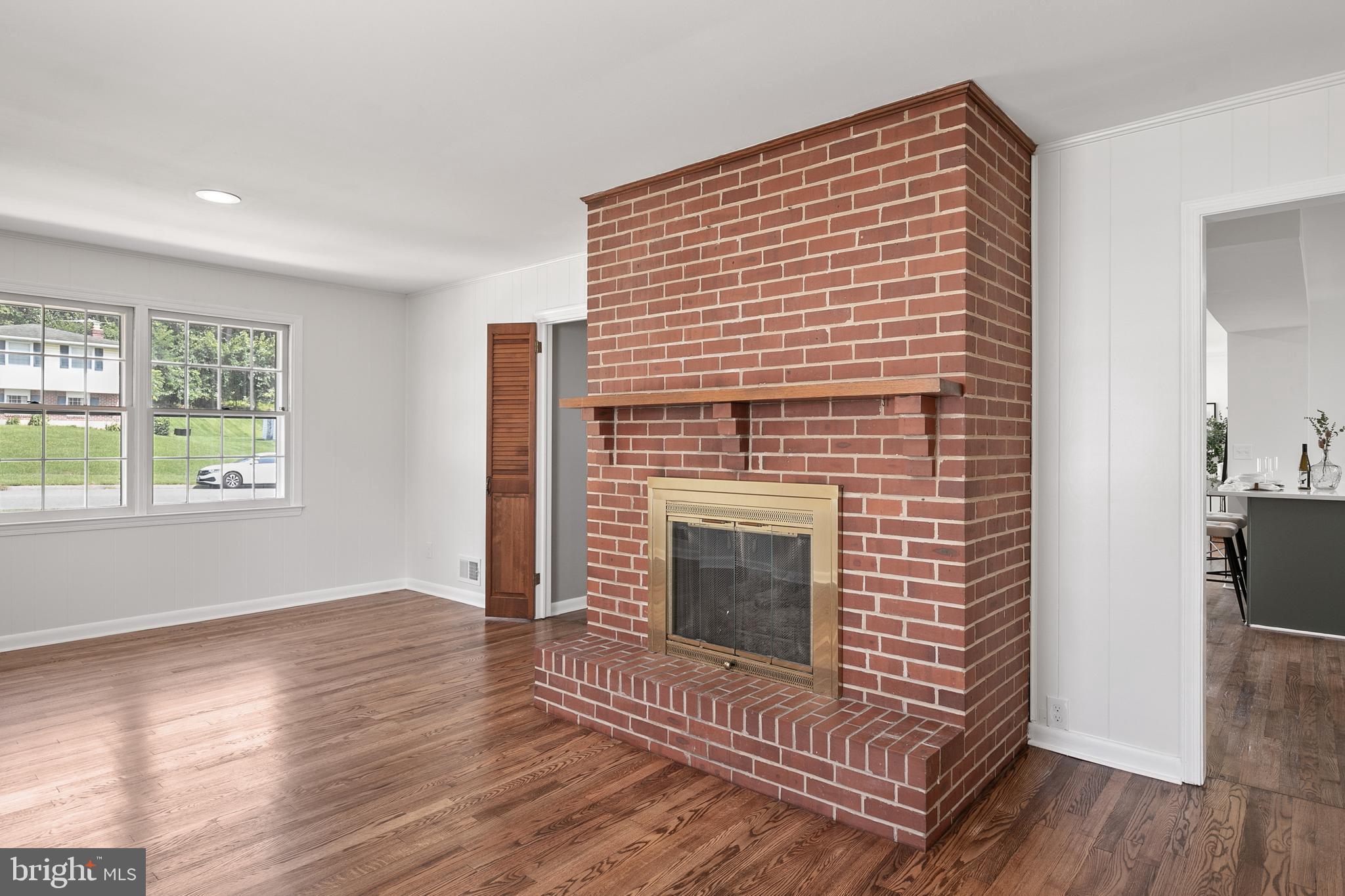 215 East Timonium Road Lutherville-Timonium, MD 21093 - Photo 13 of 33 a view of an empty room with wooden floor fireplace and a window
