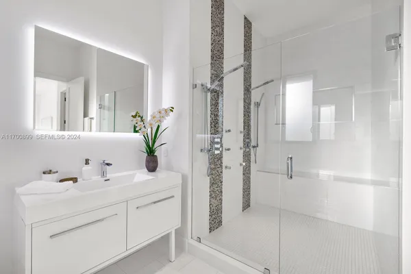 a bathroom with a sink a mirror and a shower
