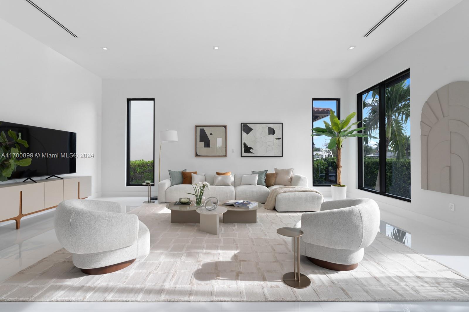 2040 Northeast 121st Road North Miami, FL 33181 - Photo 6 of 43 a living room with couches a coffee table and a flat screen tv