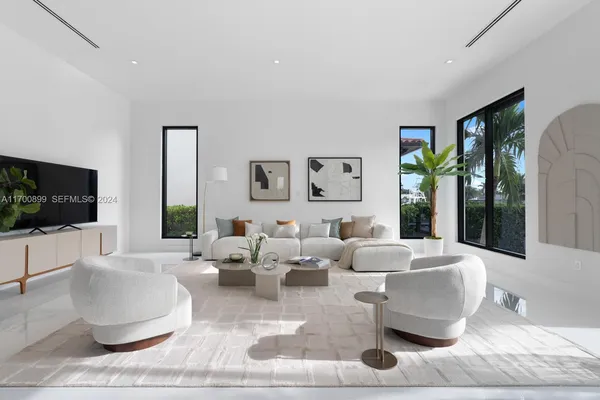 a living room with couches a coffee table and a flat screen tv