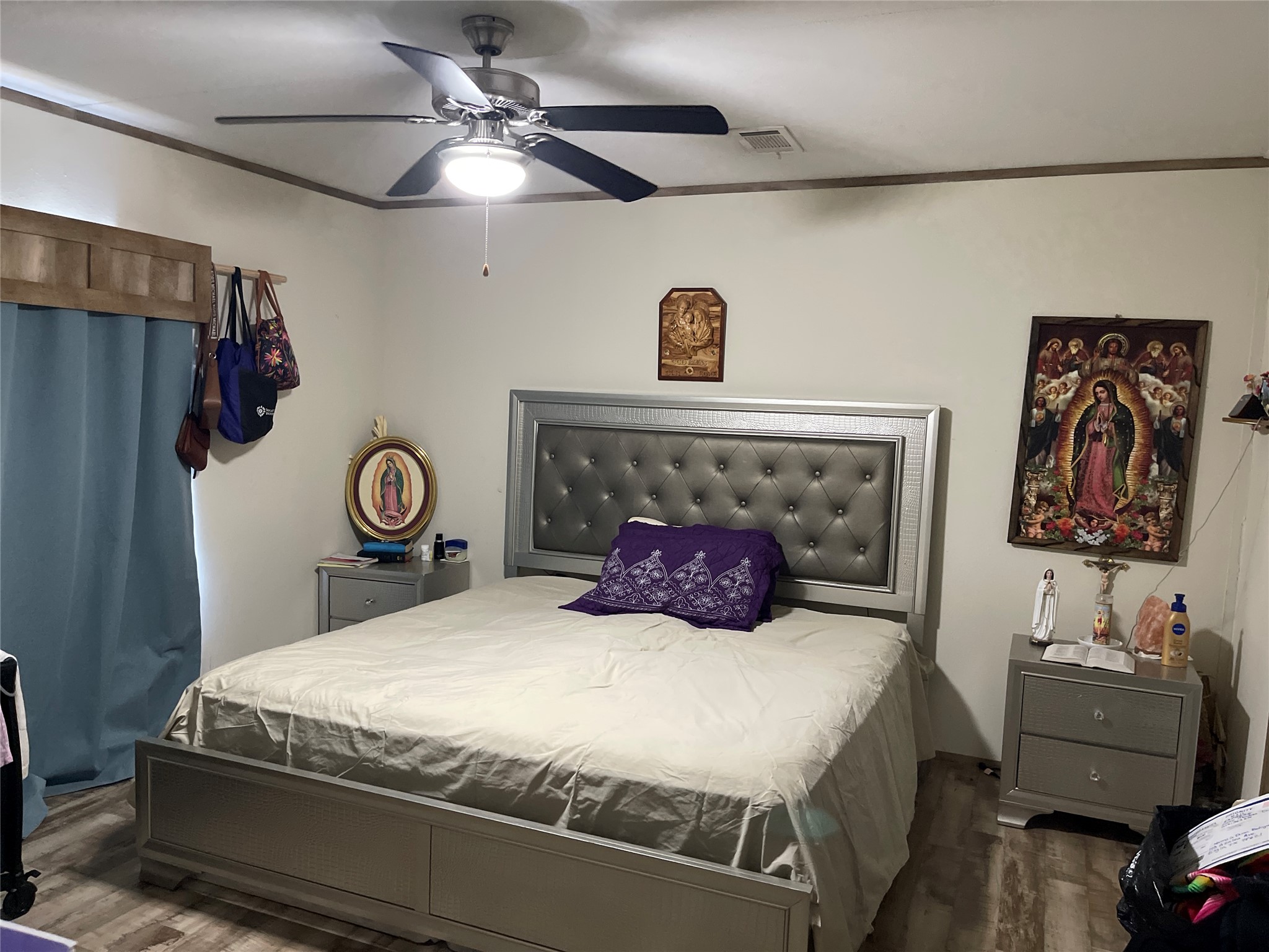 Smooth wood-look flooring and crown molding define this relaxing bedroom space.