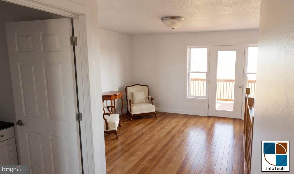 13001 Bedford Road Northeast Cumberland, MD 21502 - Photo 6 of 7 a view of an empty room with a window and wooden floor