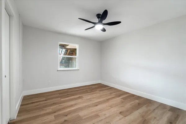 a view of a big room with wooden floor and windows