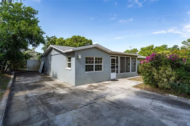 a view of a house with a yard and potted plants