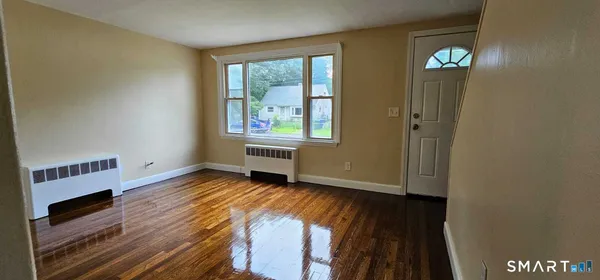 wooden floor in an empty room with a window