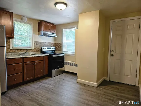 a kitchen with stainless steel appliances granite countertop a stove a sink and a refrigerator