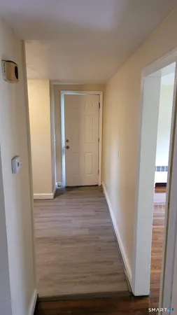 a view of a hallway with wooden floor