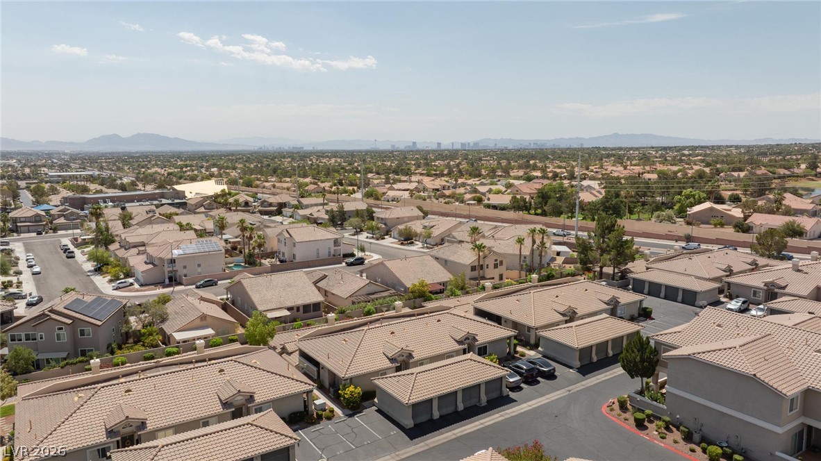 3238 Mystic Ridge Court Las Vegas, NV 89129 - Photo 28 of 31 An aerial perspective reveals a vast neighborhood spread across a wide plain, with distant mountains framing the horizon.