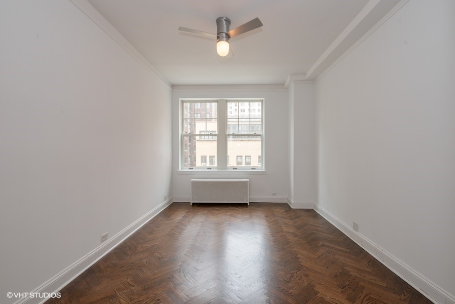 421 West Melrose Street, Unit 5B Chicago, IL 60657 - Photo 12 of 15 an empty room with wooden floor ceiling fan and windows