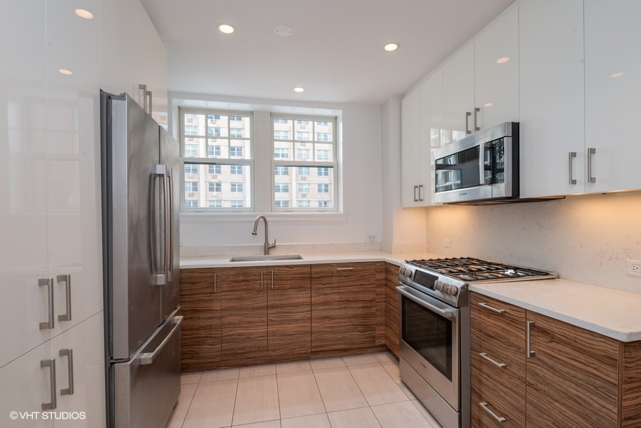 421 West Melrose Street, Unit 5B Chicago, IL 60657 - Photo 7 of 15 a kitchen with stainless steel appliances granite countertop a stove a sink and a microwave