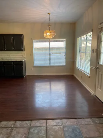 an empty room with windows and fireplace