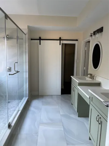 a bathroom with a granite countertop sink a toilet and shower