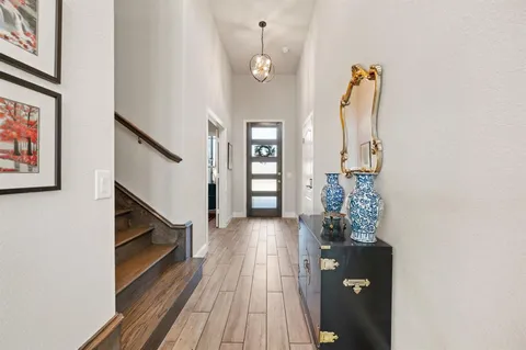 a view of a hallway with wooden floor and staircase