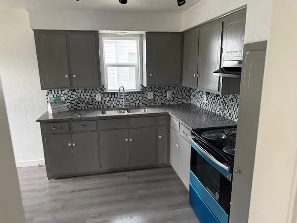 a kitchen with stainless steel appliances granite countertop a stove a sink and a refrigerator