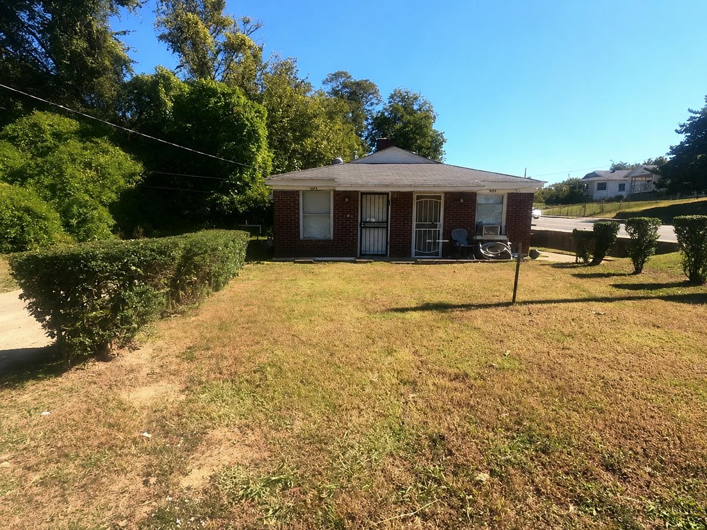 1672 Clancy Street Memphis, TN 38106 - Photo 2 of 7 Brick exterior residence featuring a front yard with established landscaping and mature trees bordering the property