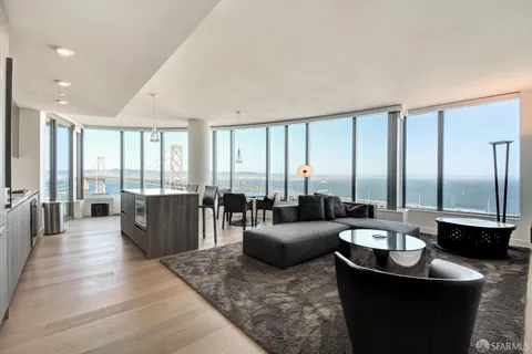 a living room with furniture large windows and a table