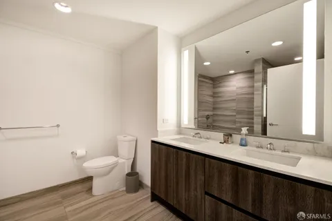 a bathroom with a double vanity sink a toilet and a mirror