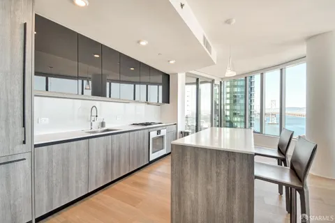 a large kitchen with kitchen island a large window in it