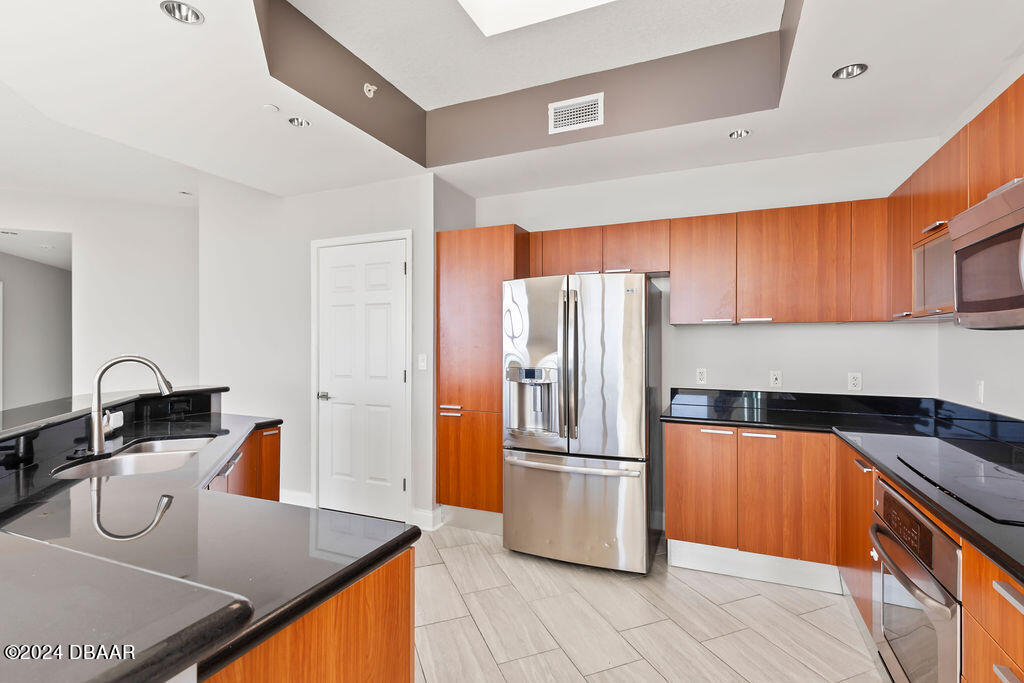 241 Riverside Drive, Unit 2610 Daytona Beach, FL 32117 - Photo 7 of 31 a kitchen with stainless steel appliances granite countertop a refrigerator and a stove