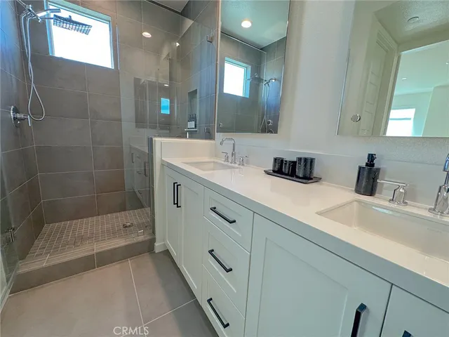 a bathroom with a shower sink and mirror