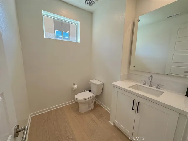 a bathroom with a toilet sink vanity and mirror