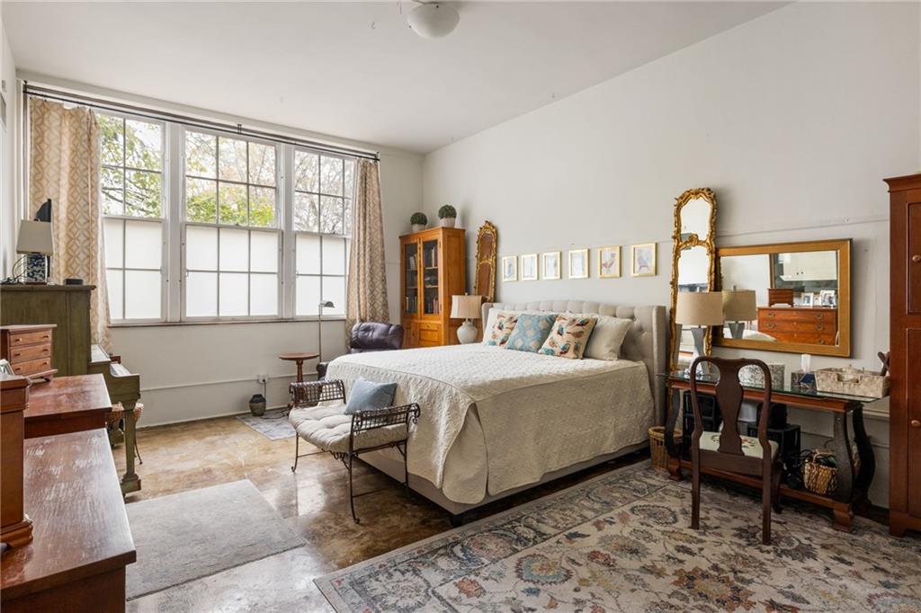 138 Kirkwood Road Northeast, Unit 14 Atlanta, GA 30317 - Photo 15 of 38 a spacious bedroom with a bed a table and large windows