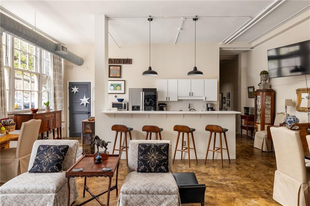 138 Kirkwood Road Northeast, Unit 14 Atlanta, GA 30317 - Photo 8 of 38 a dining hall with stainless steel appliances kitchen island granite countertop a table and chairs