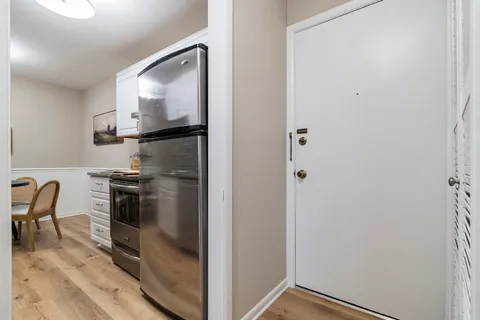 a kitchen with a refrigerator and table chairs