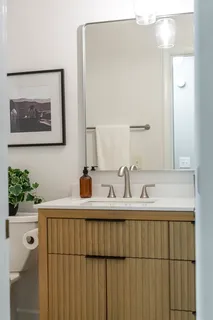 a bathroom with a sink vanity and a mirror