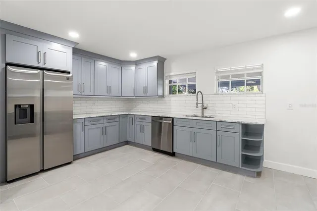 a kitchen with granite countertop a stove top oven sink and cabinets