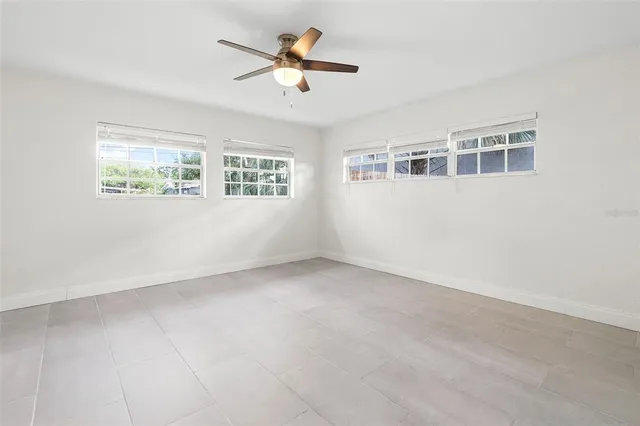 an empty room with a window and a ceiling fan